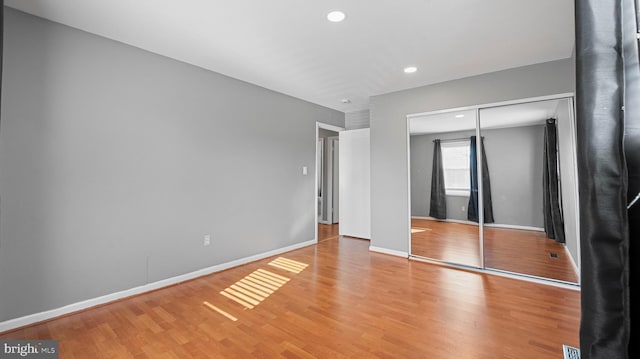 unfurnished bedroom with recessed lighting, baseboards, a closet, and light wood finished floors