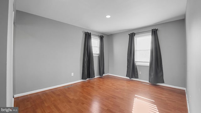 spare room with wood finished floors and baseboards