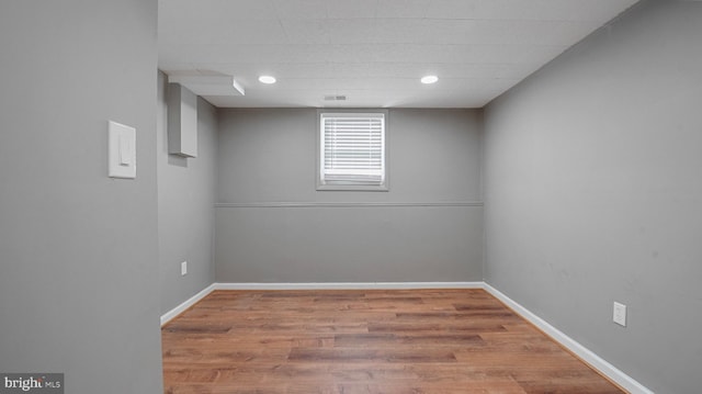 below grade area with baseboards and wood finished floors