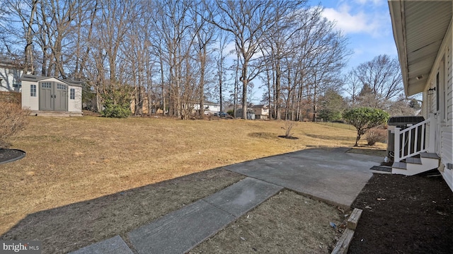 view of yard with an outbuilding, central air condition unit, a patio area, and a storage shed