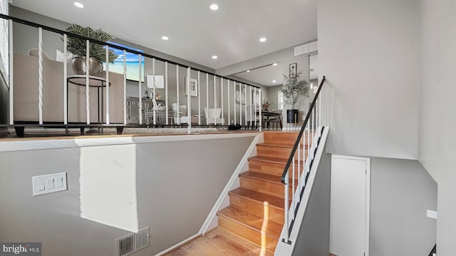 stairway featuring recessed lighting, visible vents, and wood finished floors