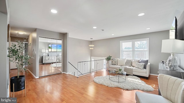 living room with recessed lighting, baseboards, and wood finished floors