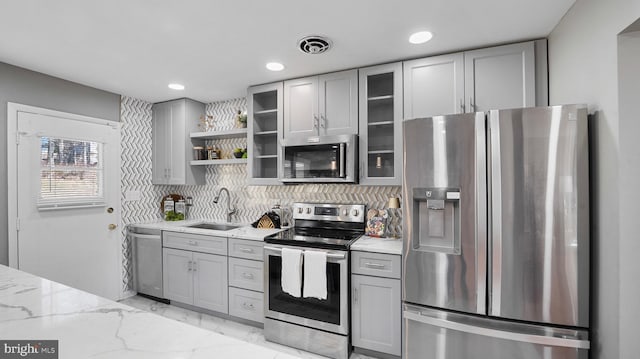 kitchen with visible vents, marble finish floor, gray cabinetry, a sink, and appliances with stainless steel finishes