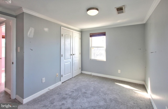 unfurnished bedroom featuring a closet, ornamental molding, and light carpet