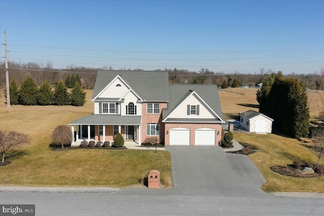 view of front facade featuring a front lawn, a porch, and a storage shed