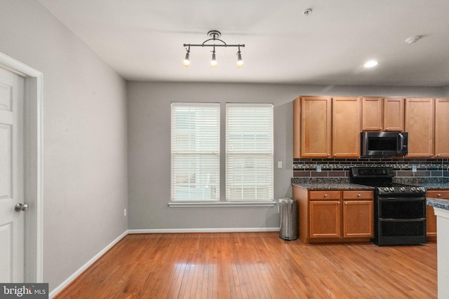 kitchen featuring black range with electric cooktop, decorative backsplash, and light wood-type flooring