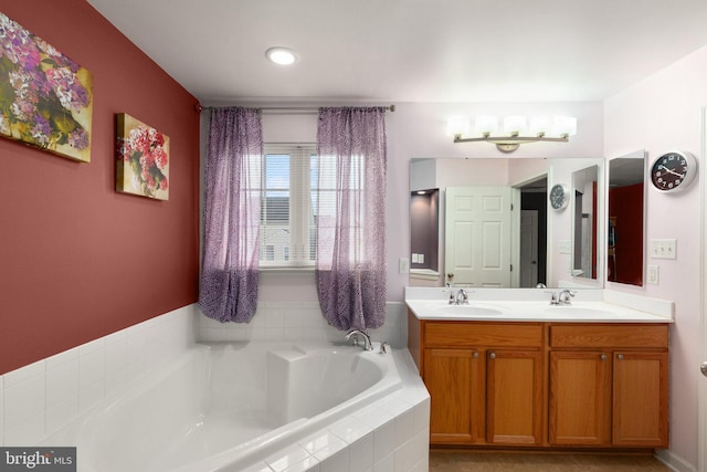 bathroom with vanity and tiled bath