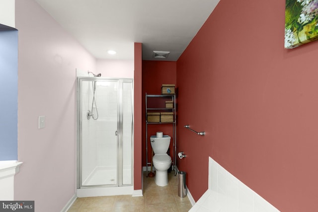 bathroom featuring tile patterned flooring, toilet, and walk in shower