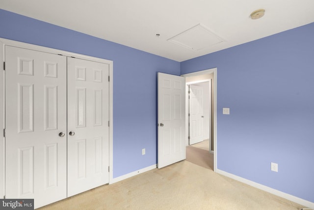 unfurnished bedroom featuring a closet and light carpet