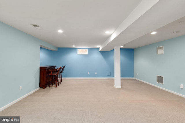 interior space featuring light colored carpet and indoor bar