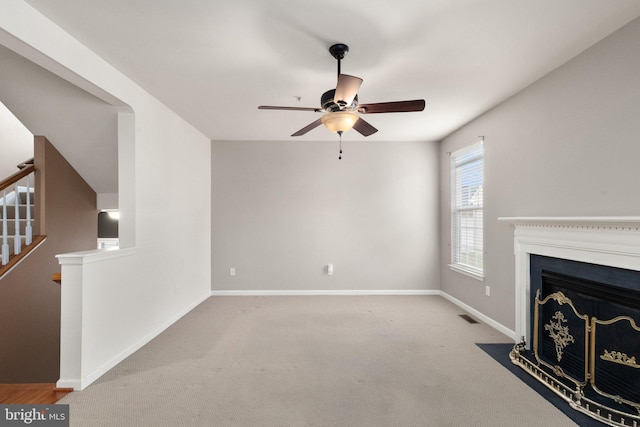 unfurnished living room featuring light colored carpet and ceiling fan