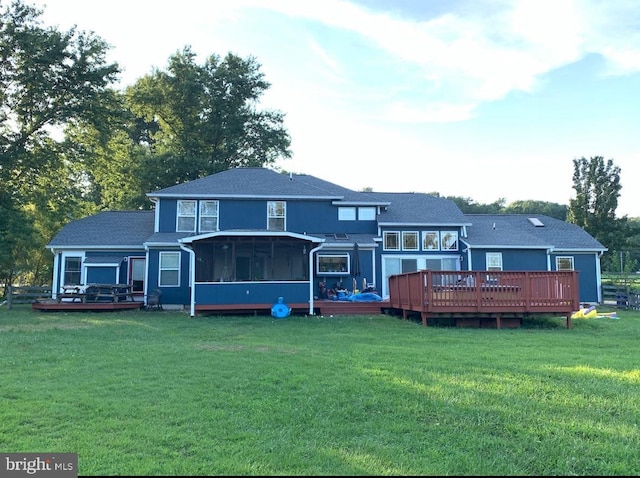 back of house featuring a lawn, a sunroom, and a deck