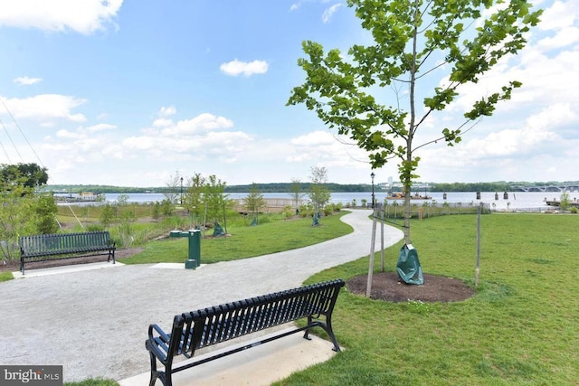 view of home's community with a lawn and a water view