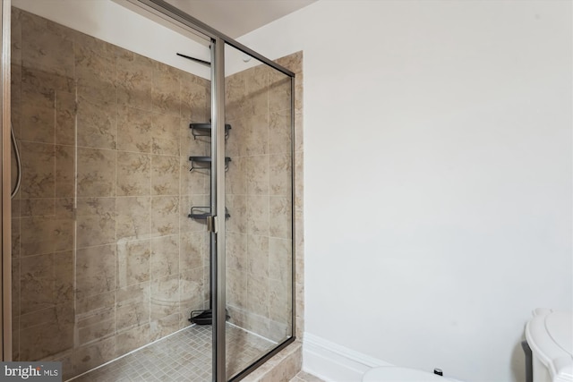 full bath with baseboards, toilet, and a stall shower