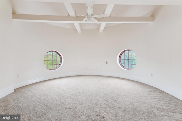 spare room with carpet floors, beam ceiling, and a wealth of natural light