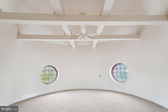 carpeted empty room featuring plenty of natural light, beam ceiling, and coffered ceiling