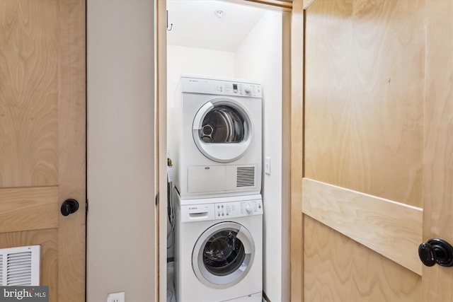 laundry room with visible vents, stacked washer and dryer, and laundry area