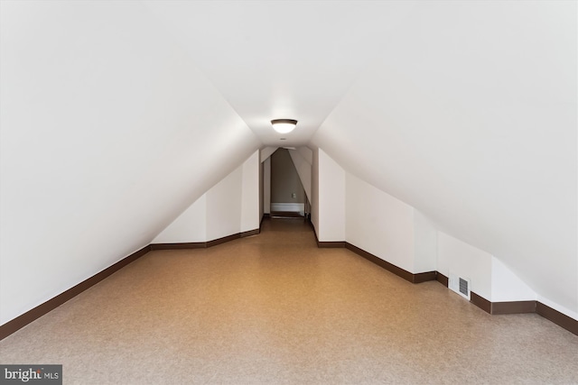 bonus room featuring vaulted ceiling, visible vents, and baseboards