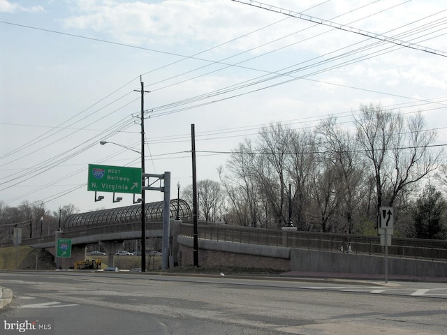 view of street featuring street lights, sidewalks, curbs, and traffic signs