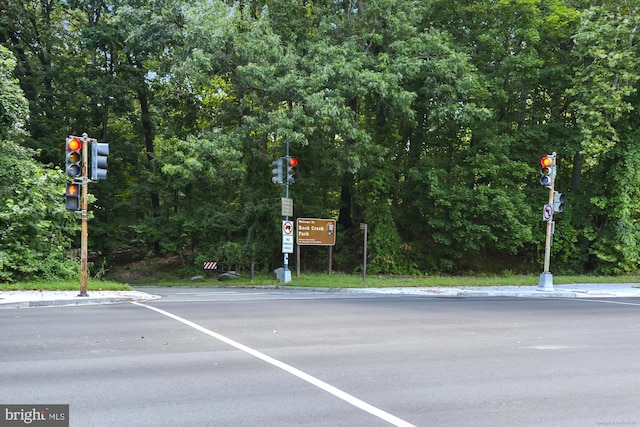 view of road with traffic signs, curbs, and traffic lights