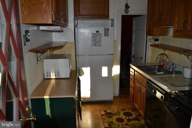 kitchen featuring white appliances, sink, and backsplash