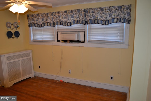 interior space with cooling unit, radiator, wood-type flooring, and ceiling fan