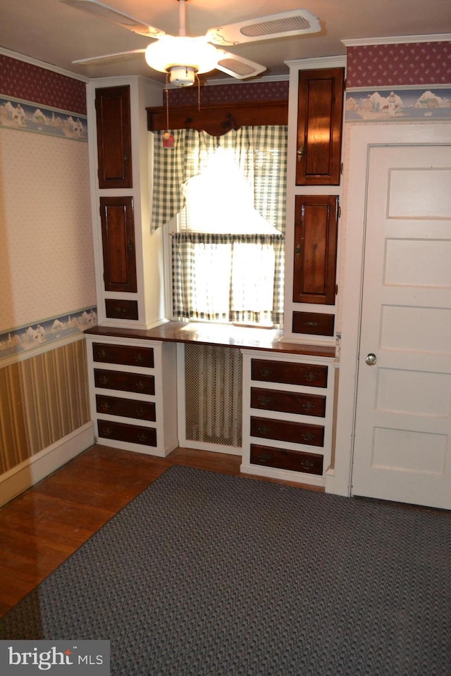 interior space with crown molding, dark wood-type flooring, and ceiling fan