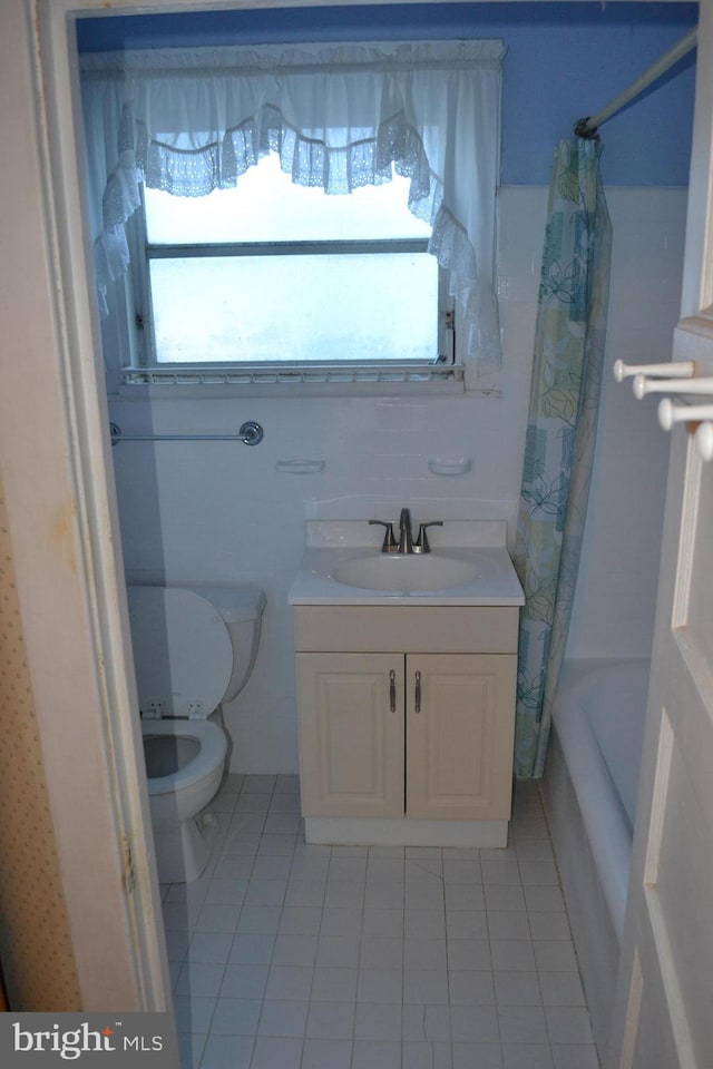 full bathroom with shower / bath combination with curtain, vanity, tile patterned floors, and toilet