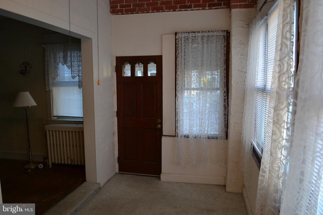 carpeted entryway with radiator heating unit