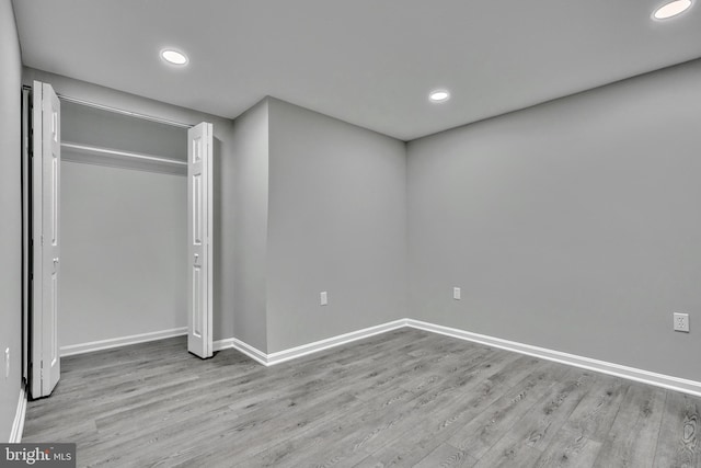 unfurnished bedroom with a closet and light hardwood / wood-style flooring