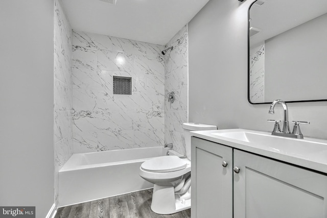 full bathroom featuring tiled shower / bath combo, wood-type flooring, vanity, and toilet