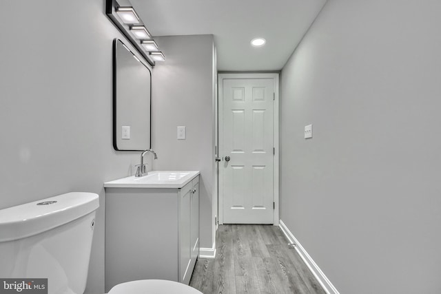 bathroom featuring vanity, hardwood / wood-style floors, and toilet