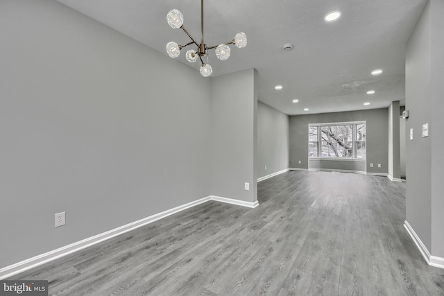 interior space featuring a textured ceiling, a chandelier, and light hardwood / wood-style flooring