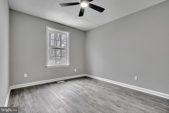 unfurnished room featuring ceiling fan, wood-type flooring, and a textured ceiling