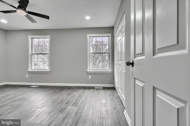 foyer entrance featuring ceiling fan, hardwood / wood-style flooring, and a healthy amount of sunlight