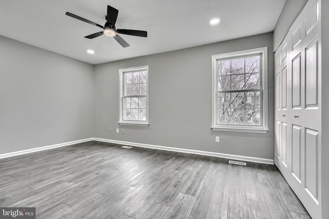 spare room featuring ceiling fan, plenty of natural light, and hardwood / wood-style floors