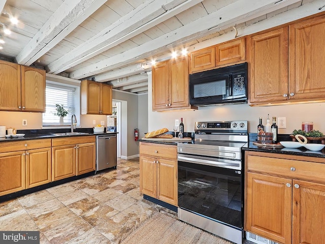 kitchen with stainless steel appliances, dark countertops, a sink, and beam ceiling