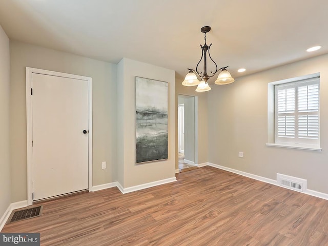 interior space with wood finished floors, visible vents, and baseboards