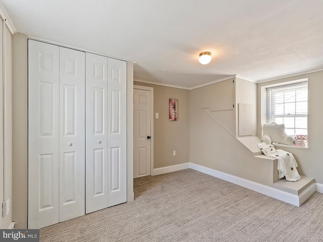 below grade area with baseboards, ornamental molding, and light colored carpet