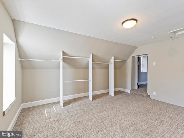 bonus room with vaulted ceiling and carpet flooring