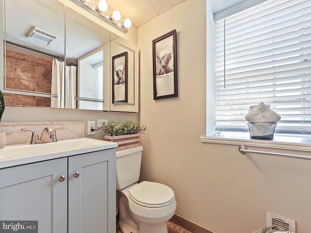 bathroom with toilet, curtained shower, visible vents, and vanity