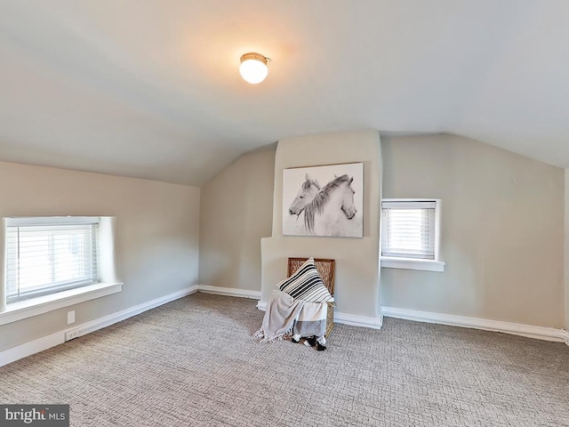 bonus room featuring lofted ceiling, carpet floors, and baseboards