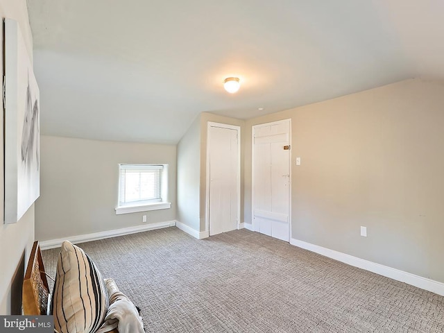 additional living space with baseboards, vaulted ceiling, and carpet flooring