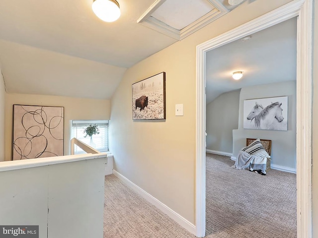 corridor with carpet, lofted ceiling, attic access, an upstairs landing, and baseboards