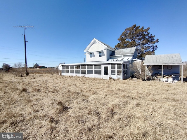 rear view of property featuring a sunroom