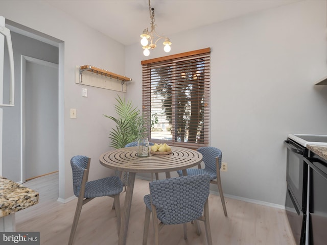 dining space featuring light wood-style flooring, baseboards, and an inviting chandelier