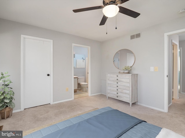 bedroom with ensuite bathroom, light carpet, a ceiling fan, visible vents, and baseboards