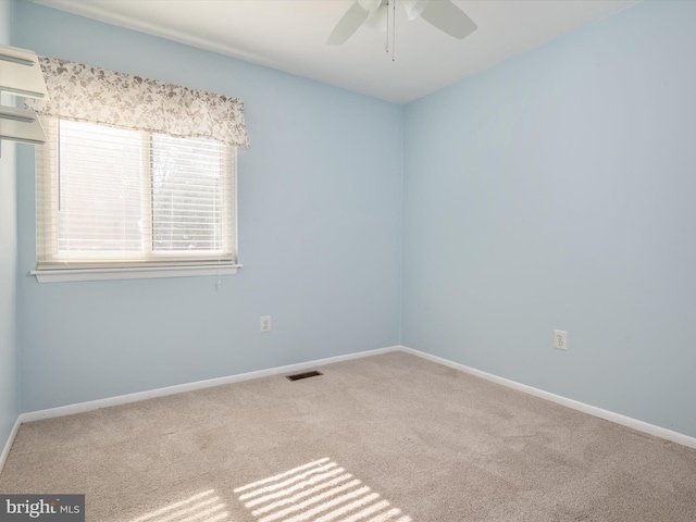 empty room featuring a ceiling fan, carpet, visible vents, and baseboards