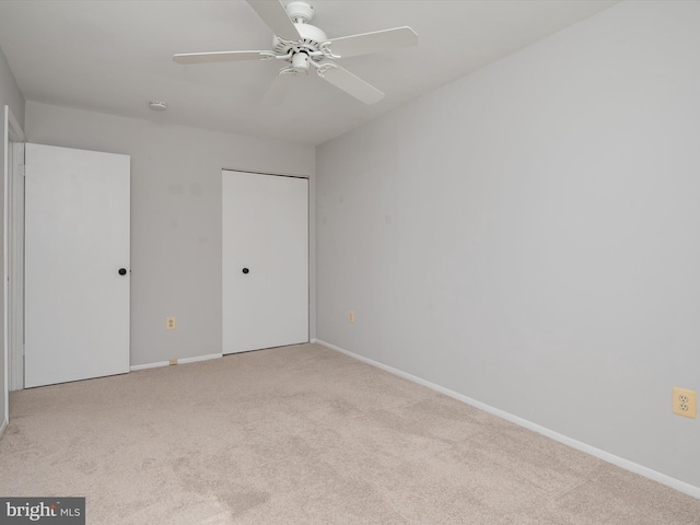 unfurnished bedroom featuring light carpet, ceiling fan, and baseboards