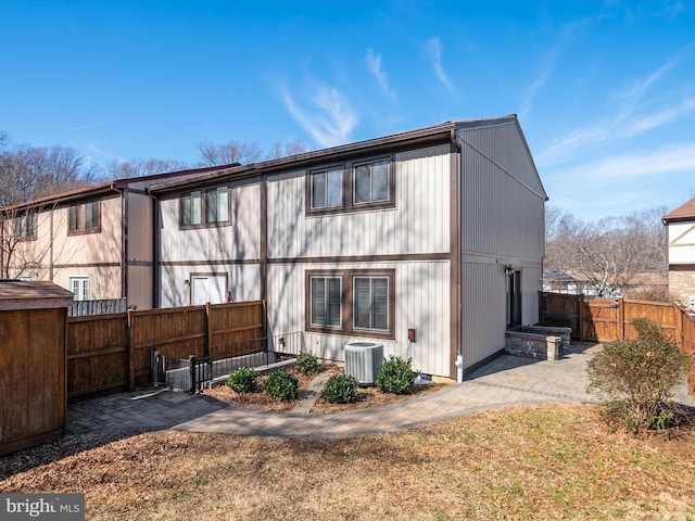 back of house with central AC unit, a lawn, a patio area, and fence private yard